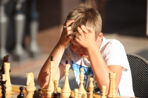 мальчик играет в шахматы в солнечный день в центре Москвы на фестивале варенья
